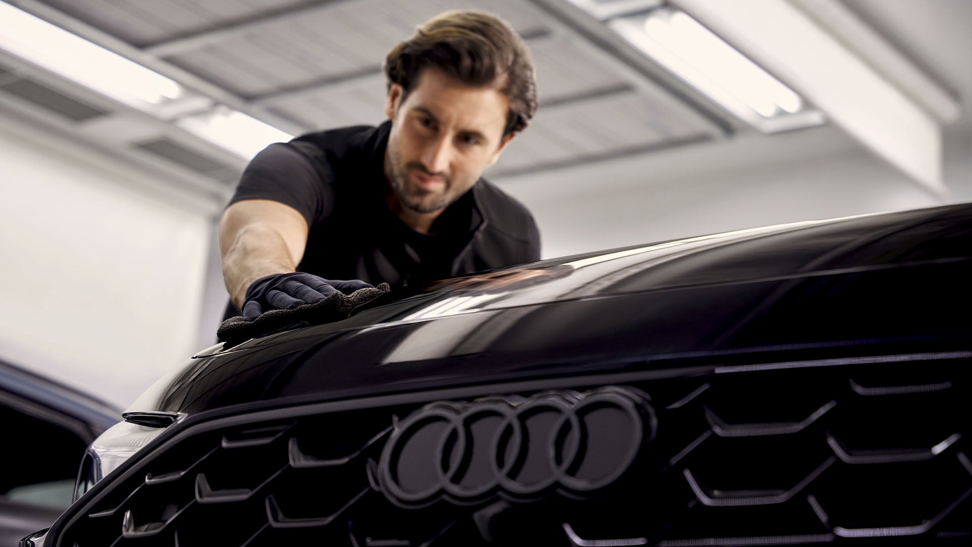 Un employé nettoie le capot d'une Audi