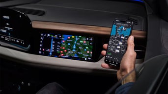 Person in the passenger seat of the 2026 Audi A6 e-tron looking at their mobile phone.