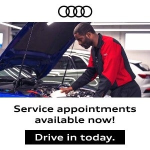 Mechanic checking under the hood of an Audi