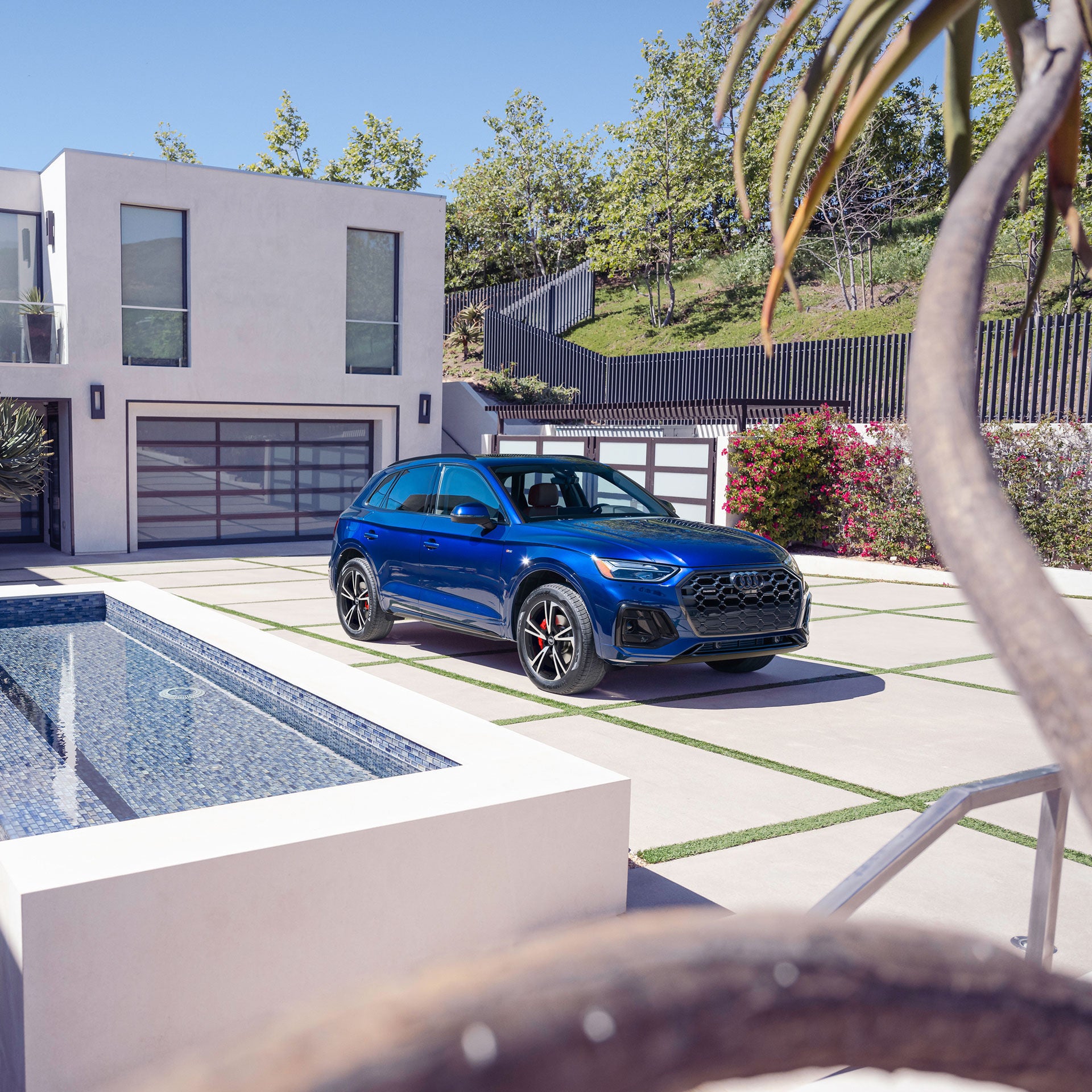 Three-quarter front view of the Audi Q5 parked in front of a modern house.
