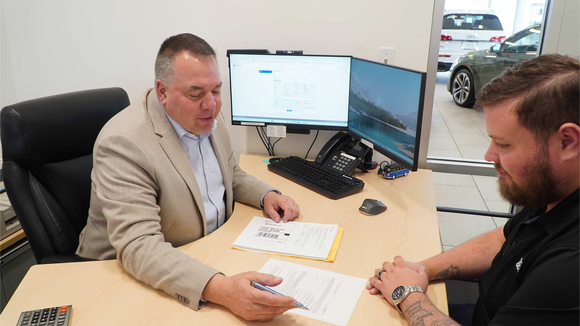An Audi dealer sitting with a customer in their office