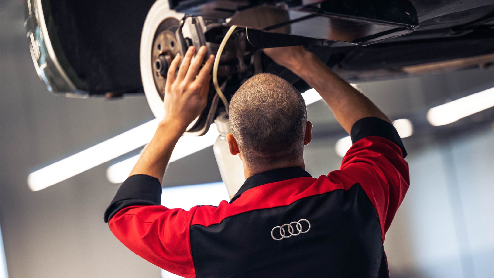 Audi service technician servicing a vehicle.