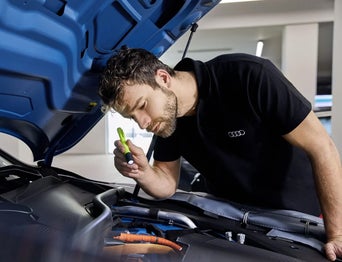 Service technician serving vehicle.