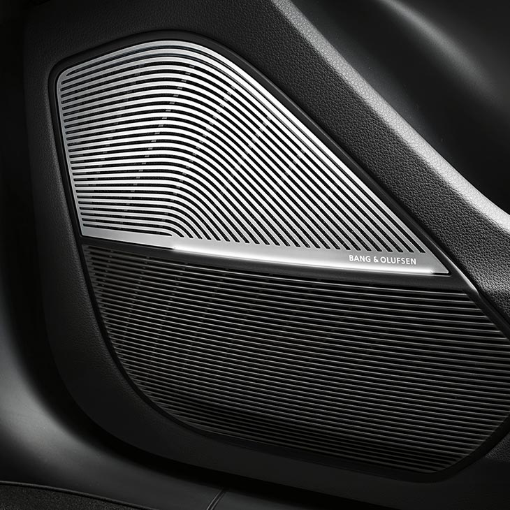 A close-up photo of a Bang & Olufsen speaker inside an Audi vehicle.