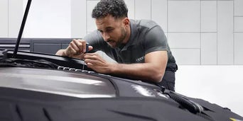 Service technician servicing vehicle.