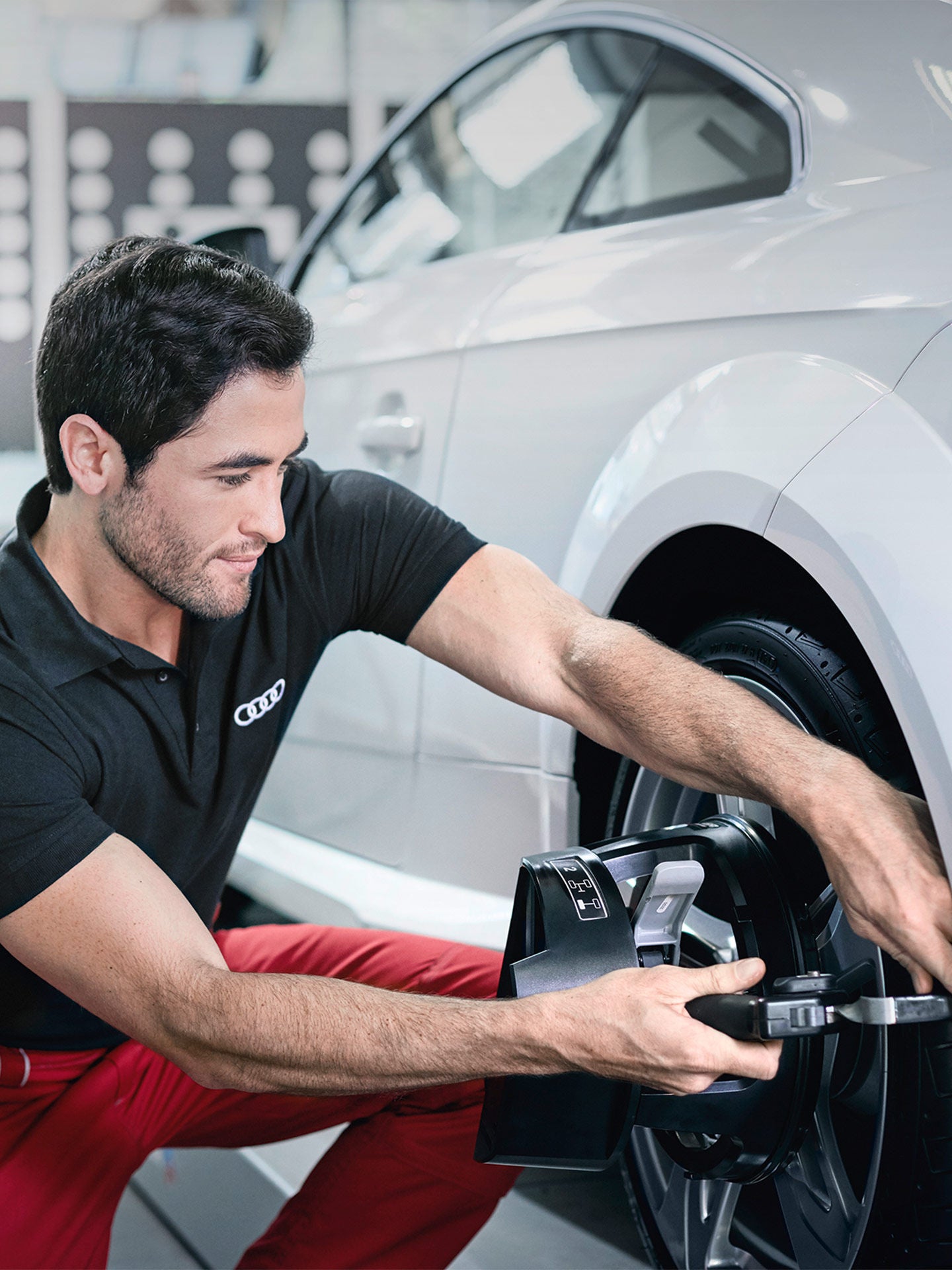 Un technicien Audi inspecte un véhicule Audi.