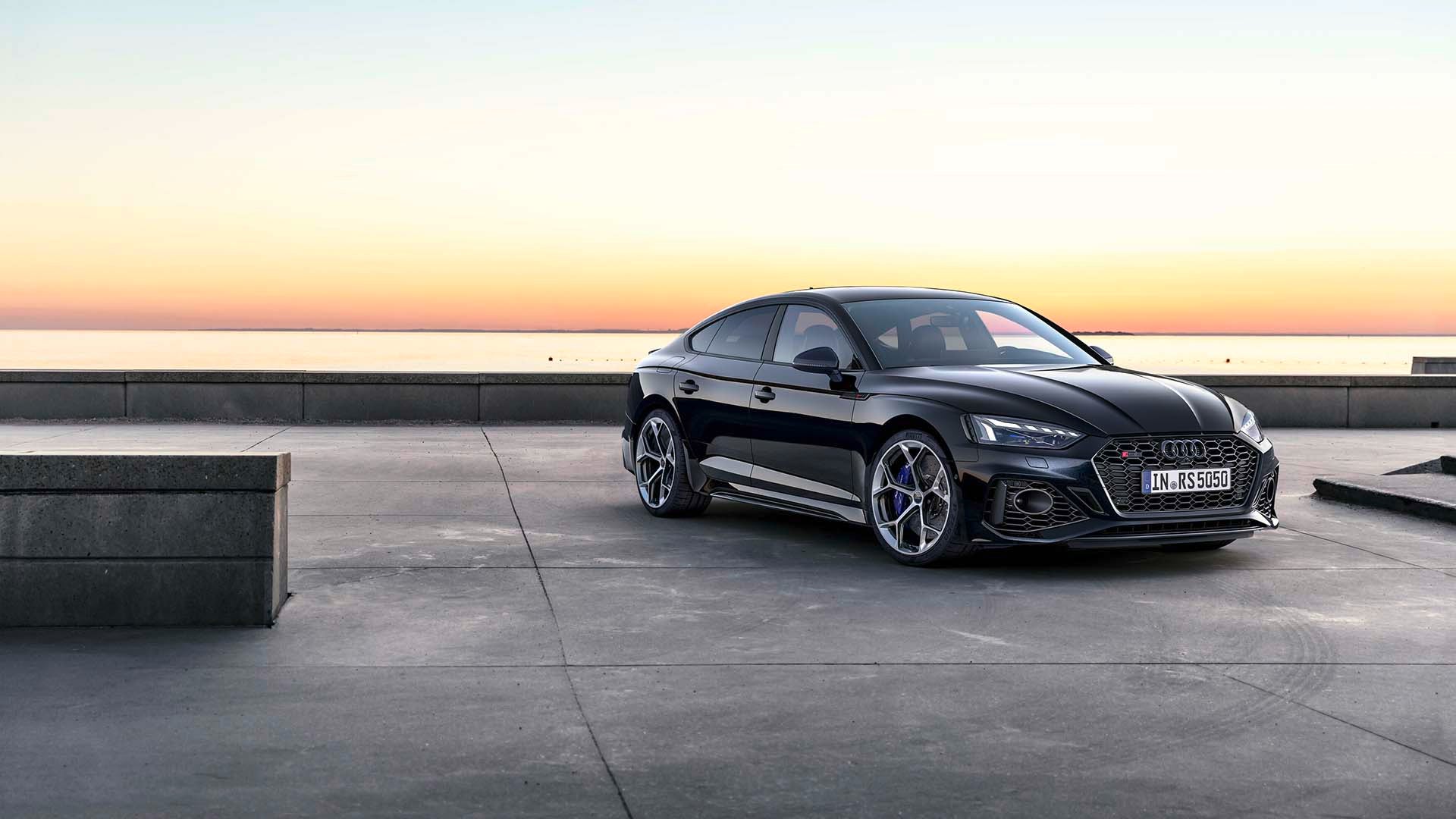 Three quarter profile view of an Audi RS 5 Sportback parked.