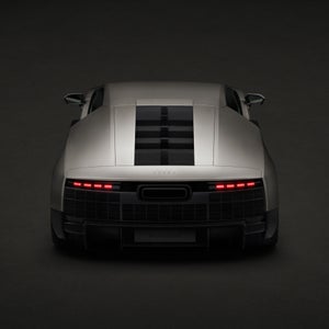 Aerial rear profile of the Audi Nuvolari parked in a darkened room.