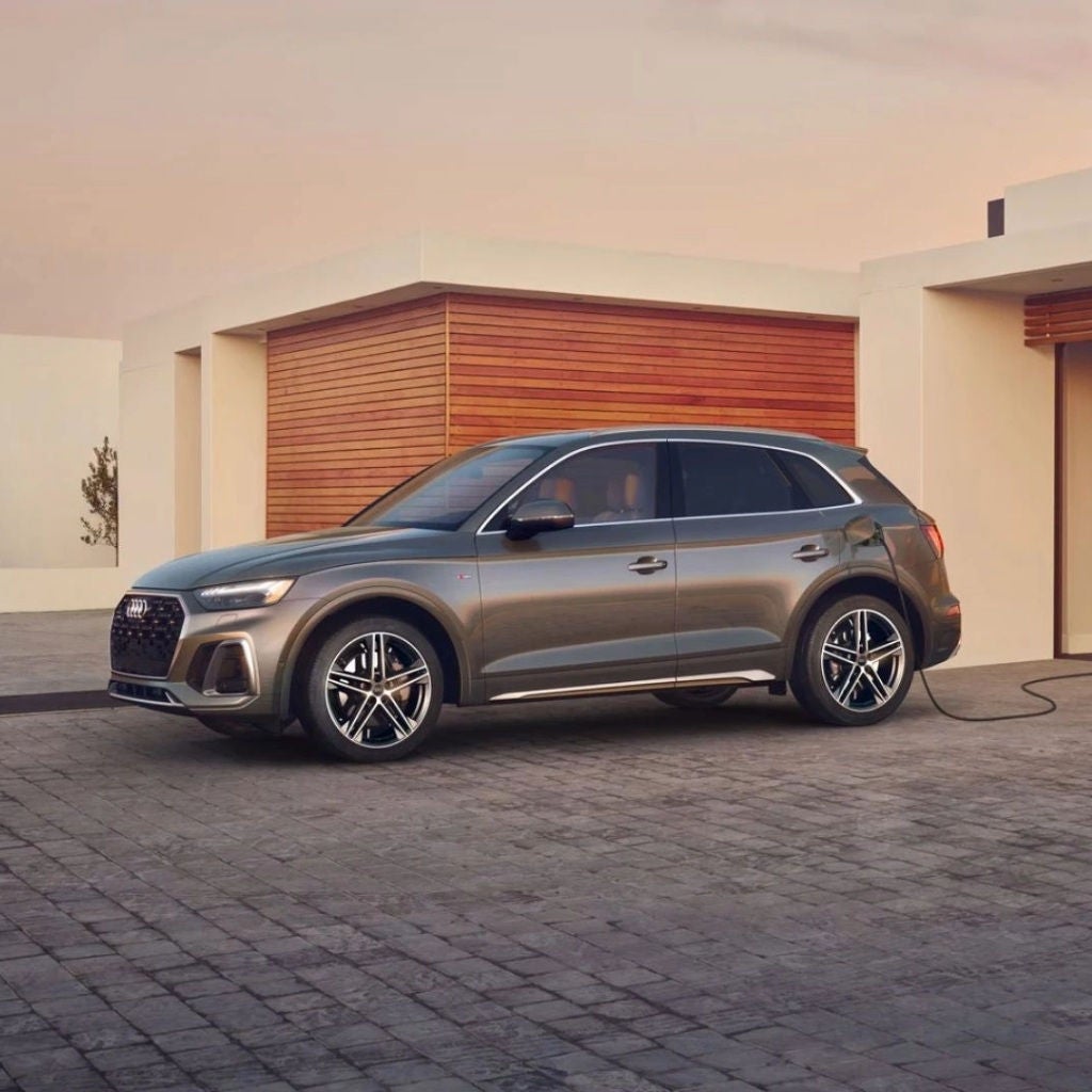 Left profile view of an Audi SUV parked in driveway.