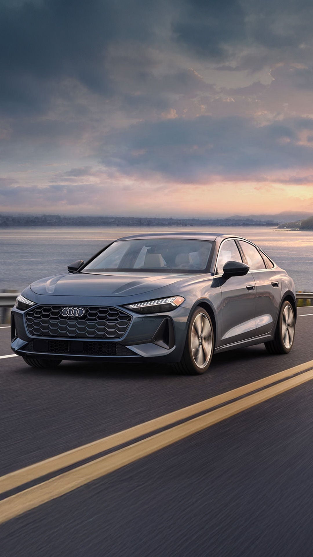 Three-quarter front view of the Audi A5 accelerating on an oceanside road.
