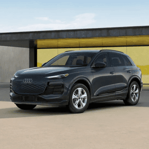 Front 3/4 view of an Audi Q6 e-tron parked outside a modern building