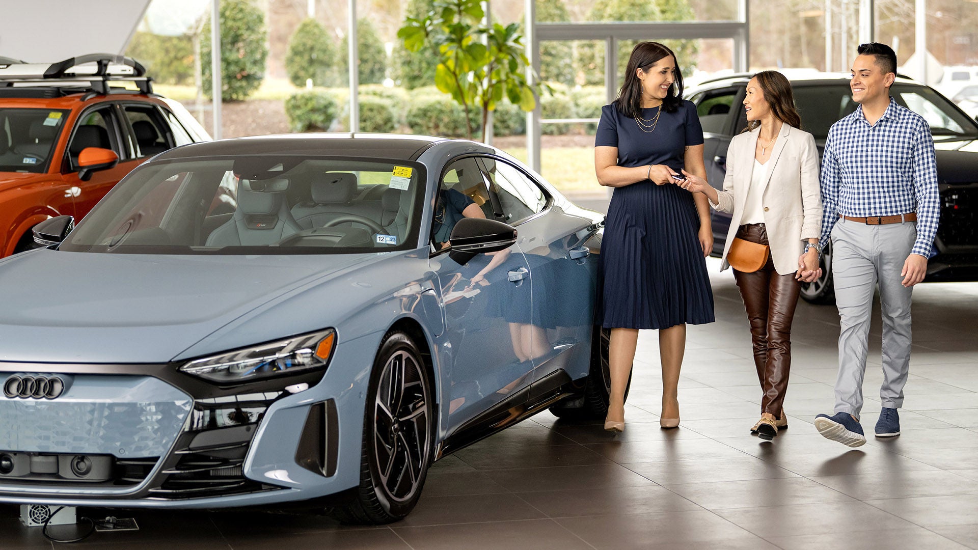 Audi Brand Specialist working with a couple in an Audi showroom.