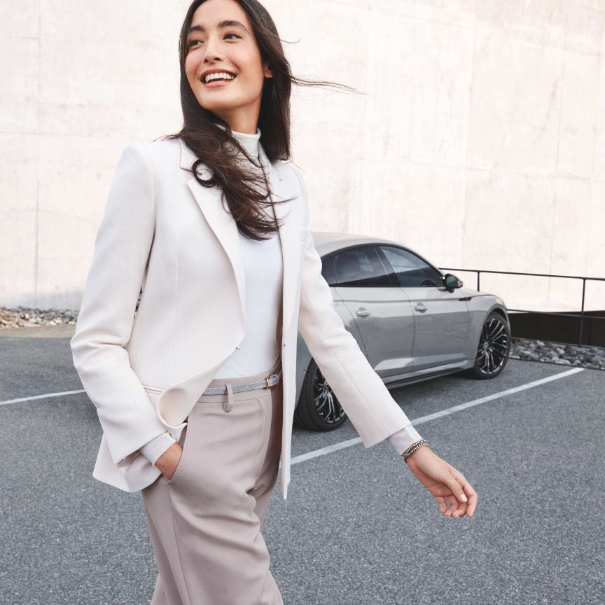 image of a woman walking away from an Audi