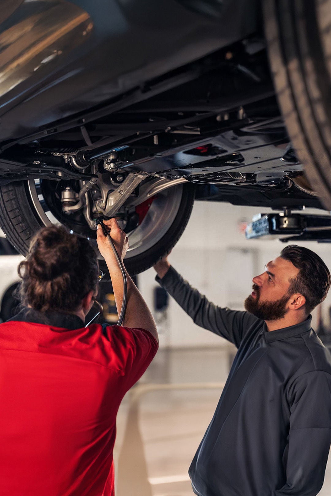 Service technician servicing a tire with another technician.