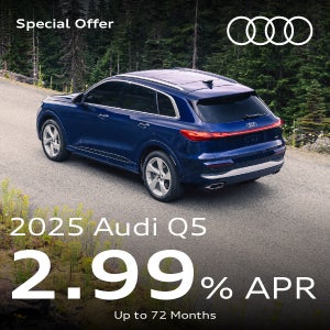 A blue Q5 parked in the forest.