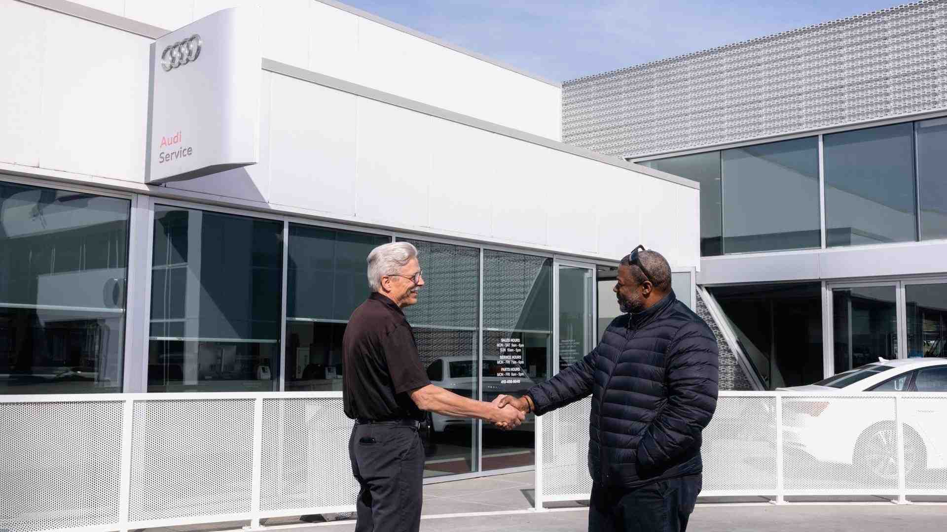 Audi Dealership manager shaking hands with a customer.