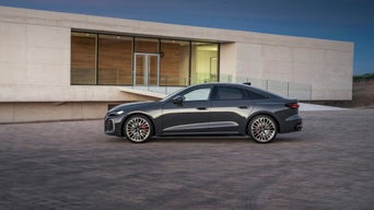 Vue de côté d’un Audi A5 stationné à distance, devant une maison