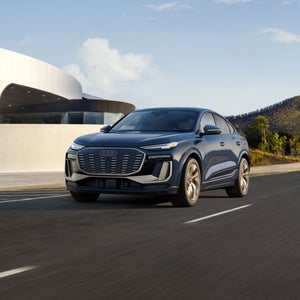 Three-quarter front view of the Audi Q6 Sportback e-tron accelerating.