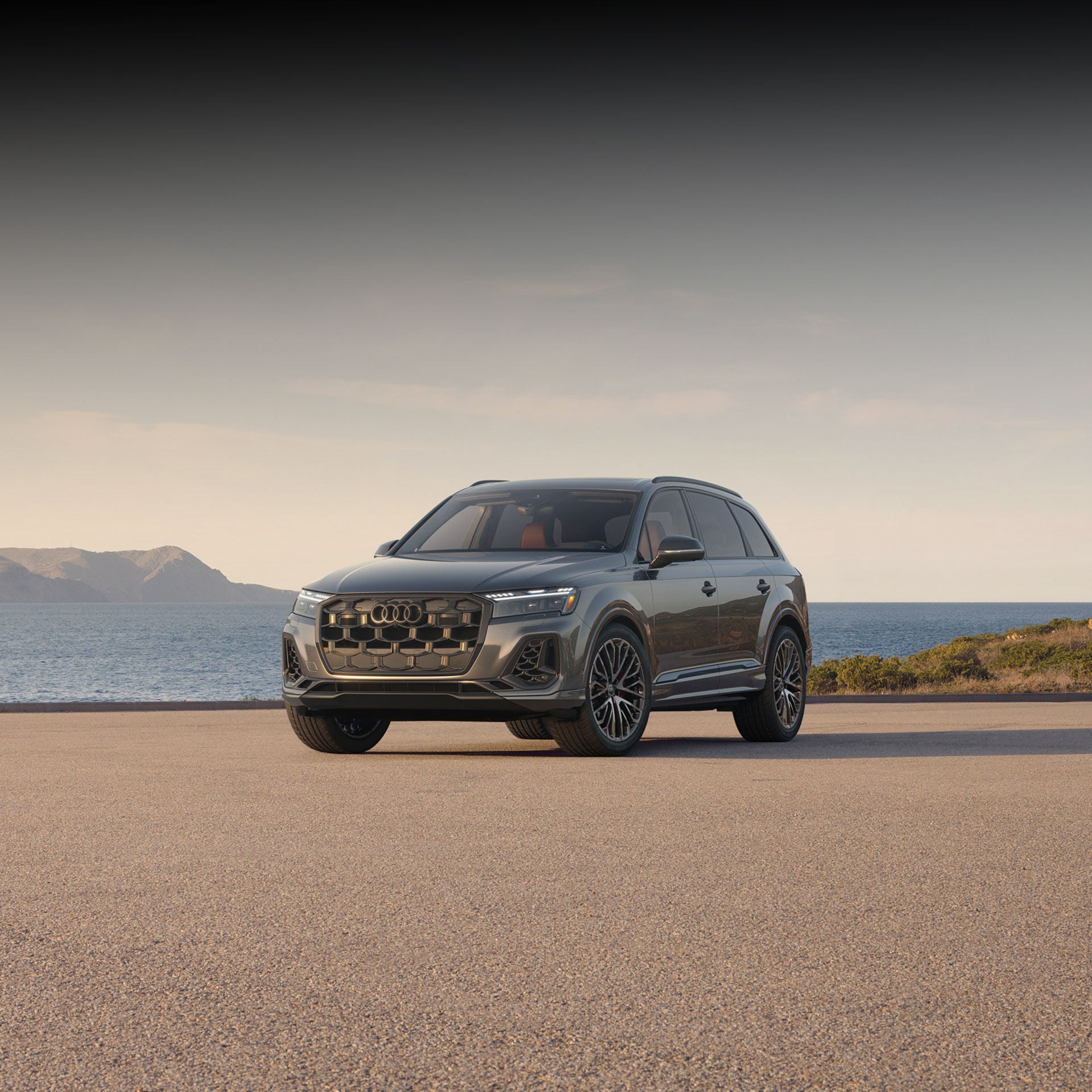 Three-quarter front view of an Audi SQ7 parked by a waterfront.