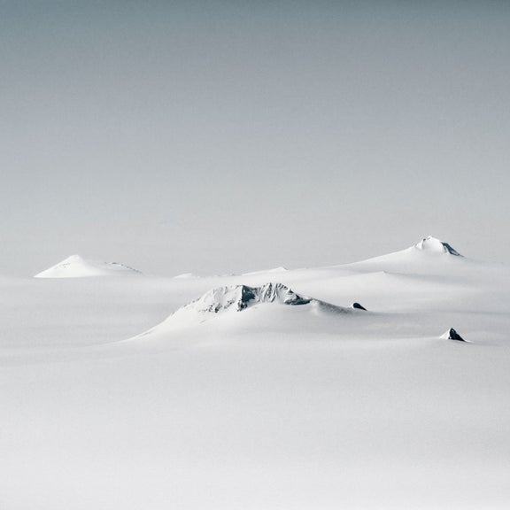 A snowy landscape featuring ice capped mountains buried in the snow.