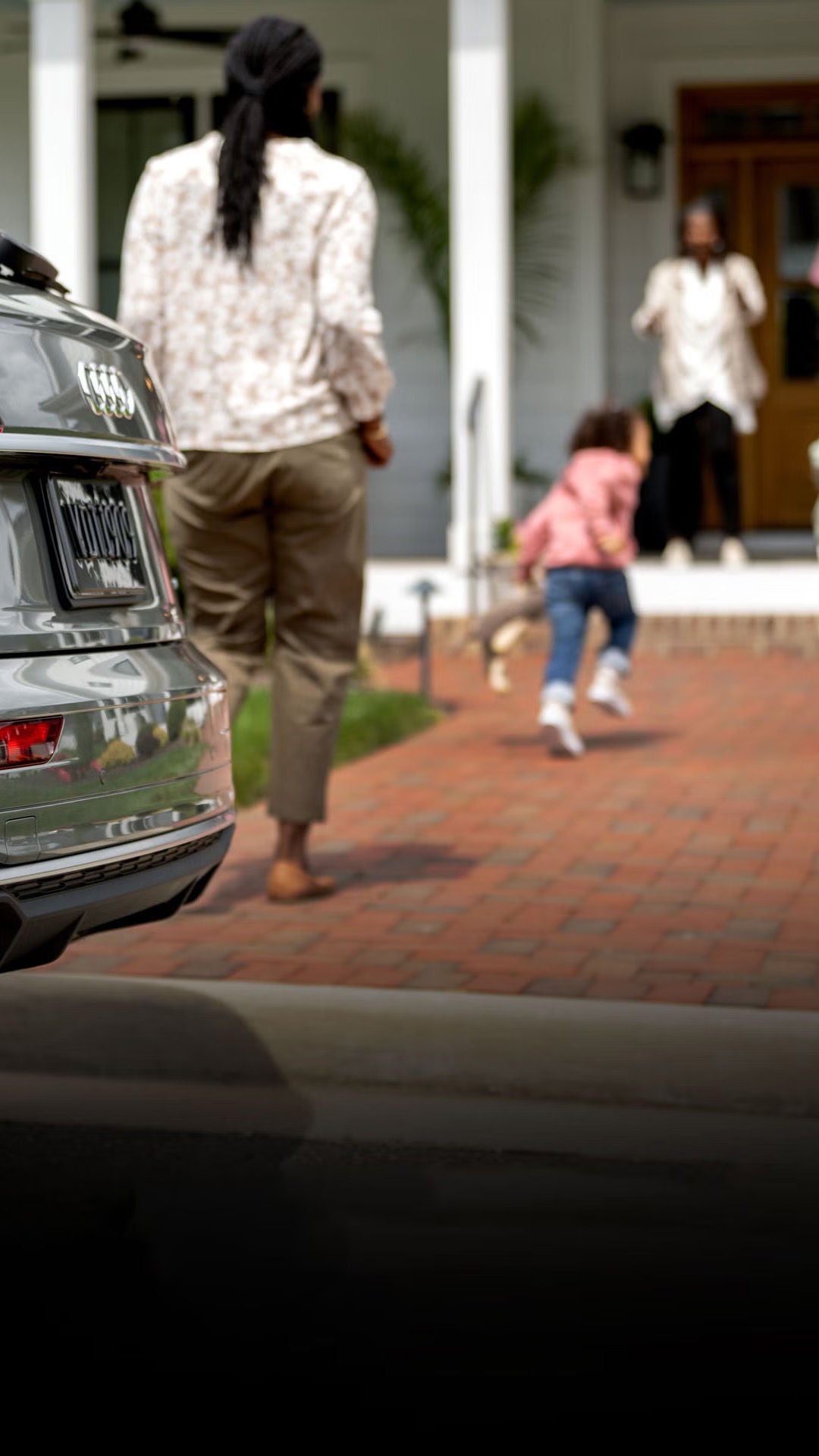 Happy family outside their home. View of Audi SUV