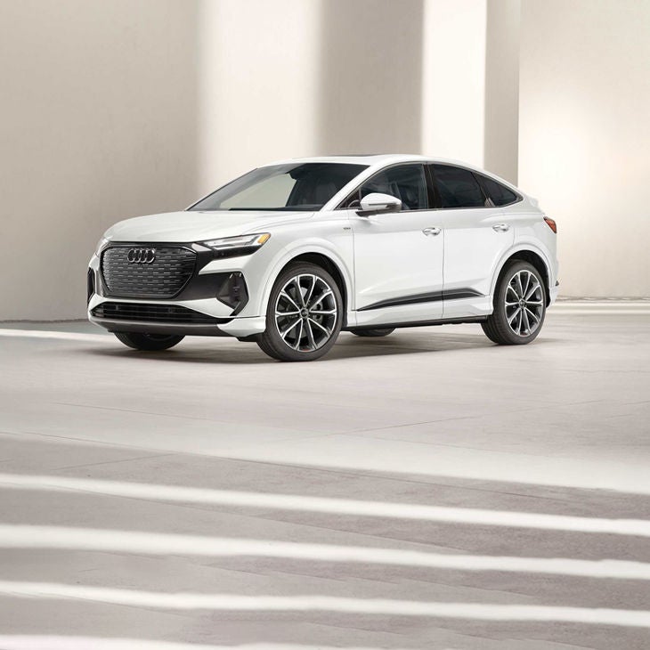 Vue de trois quarts avant de l'Audi Q4 Sportback e-tron garée.