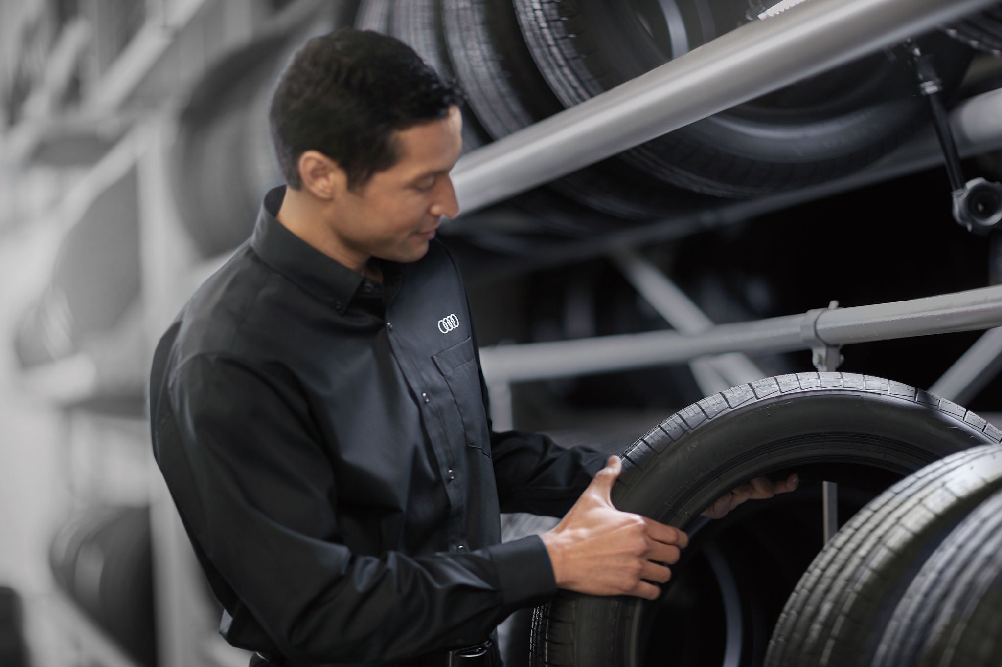 A service technician selecting a tire from a storage rack