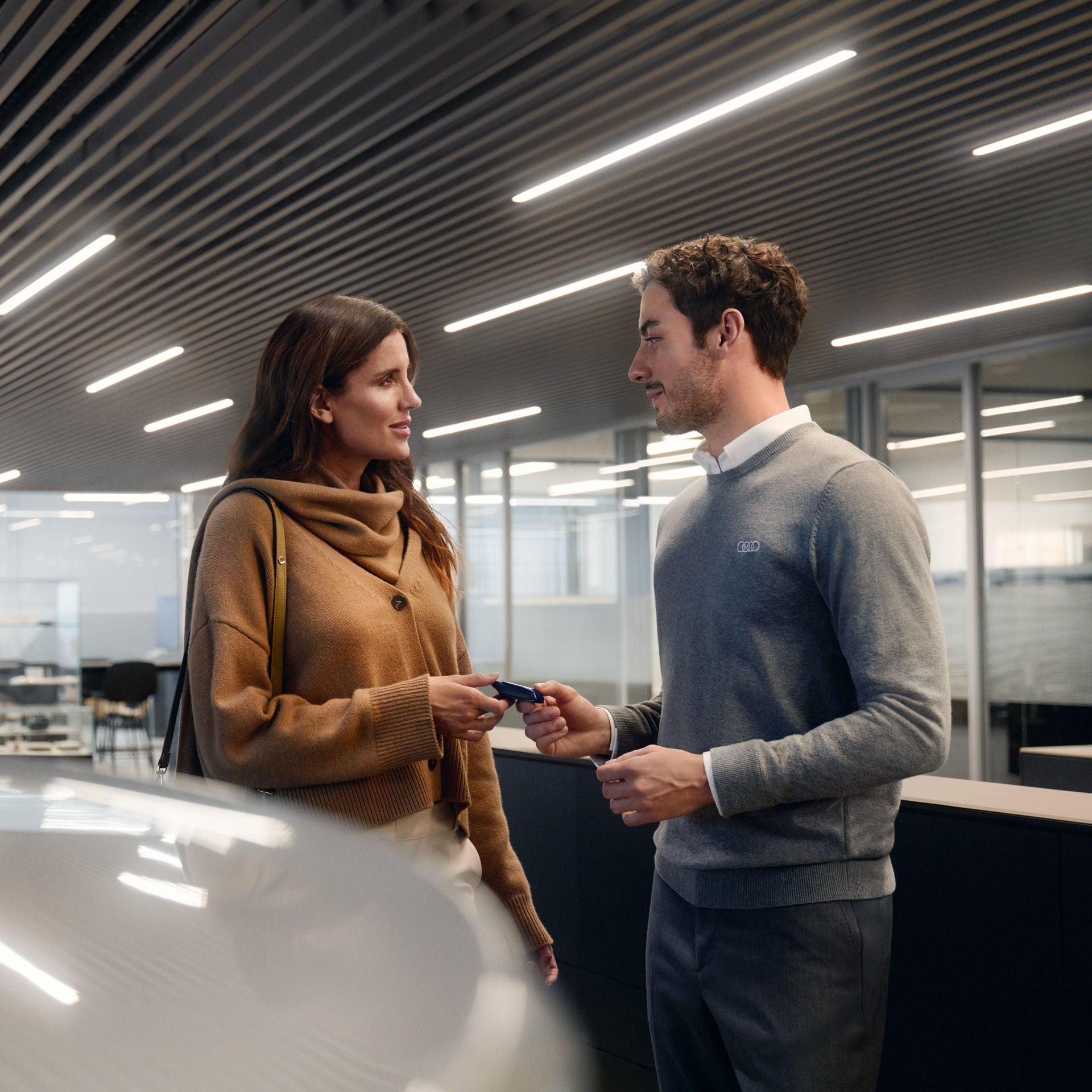Un propriétaire d'Audi remet ses clés à un employé de la marque pour un rendez-vous d'entretien.