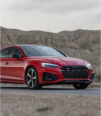 Vue d’angle d’un Audi A5 rouge garé dehors