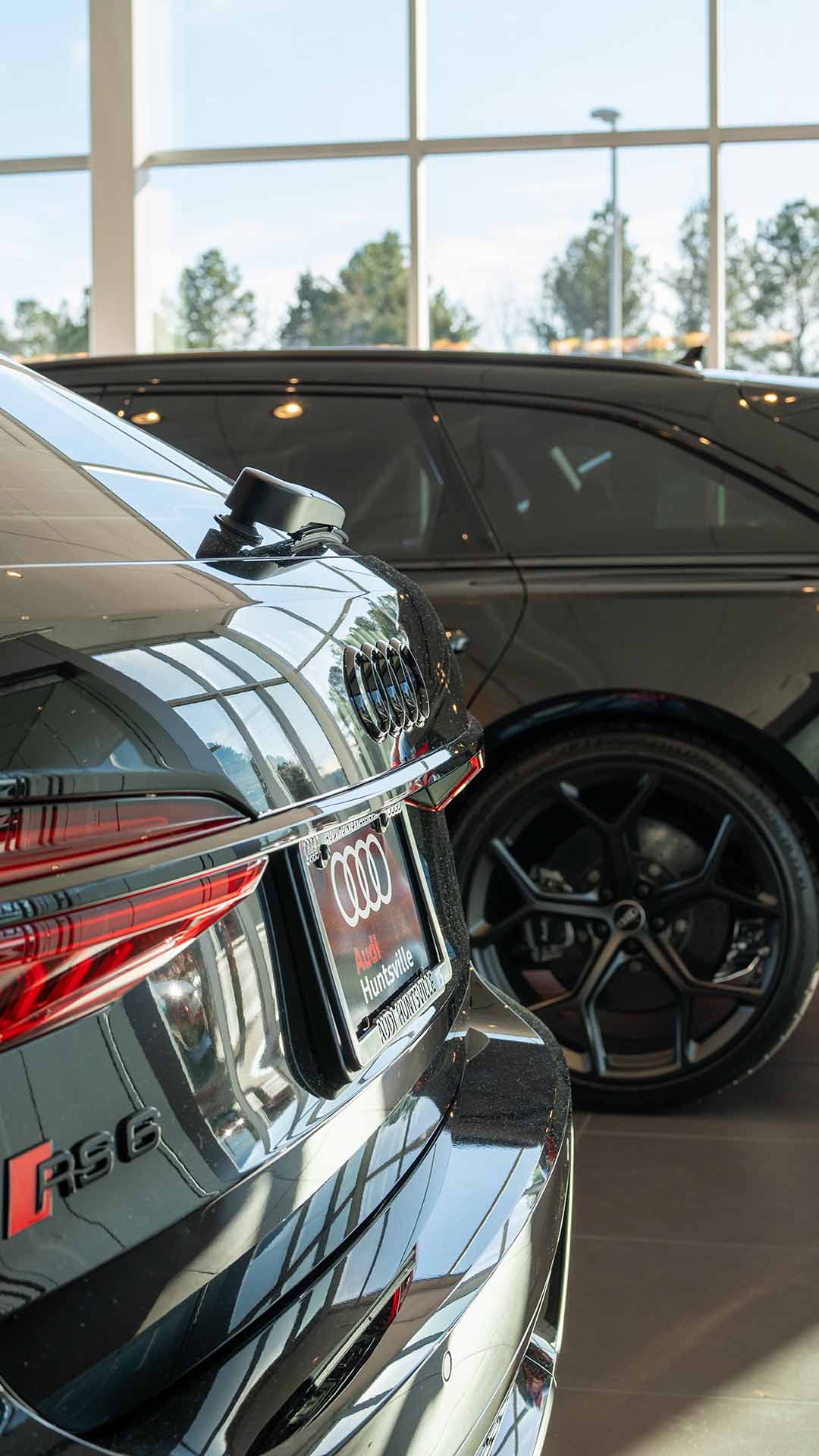 Rear profile view of audi vehicles parked in the showroom.