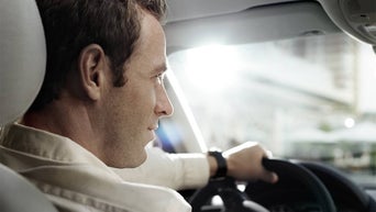 Vue par-dessus l'épaule d'une personne conduisant un véhicule Audi.