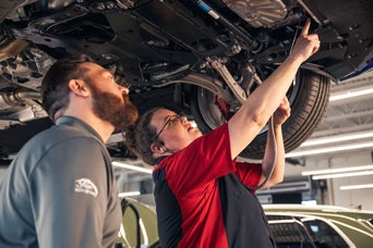 Audi technicians looking at the underside of a vehicle.
