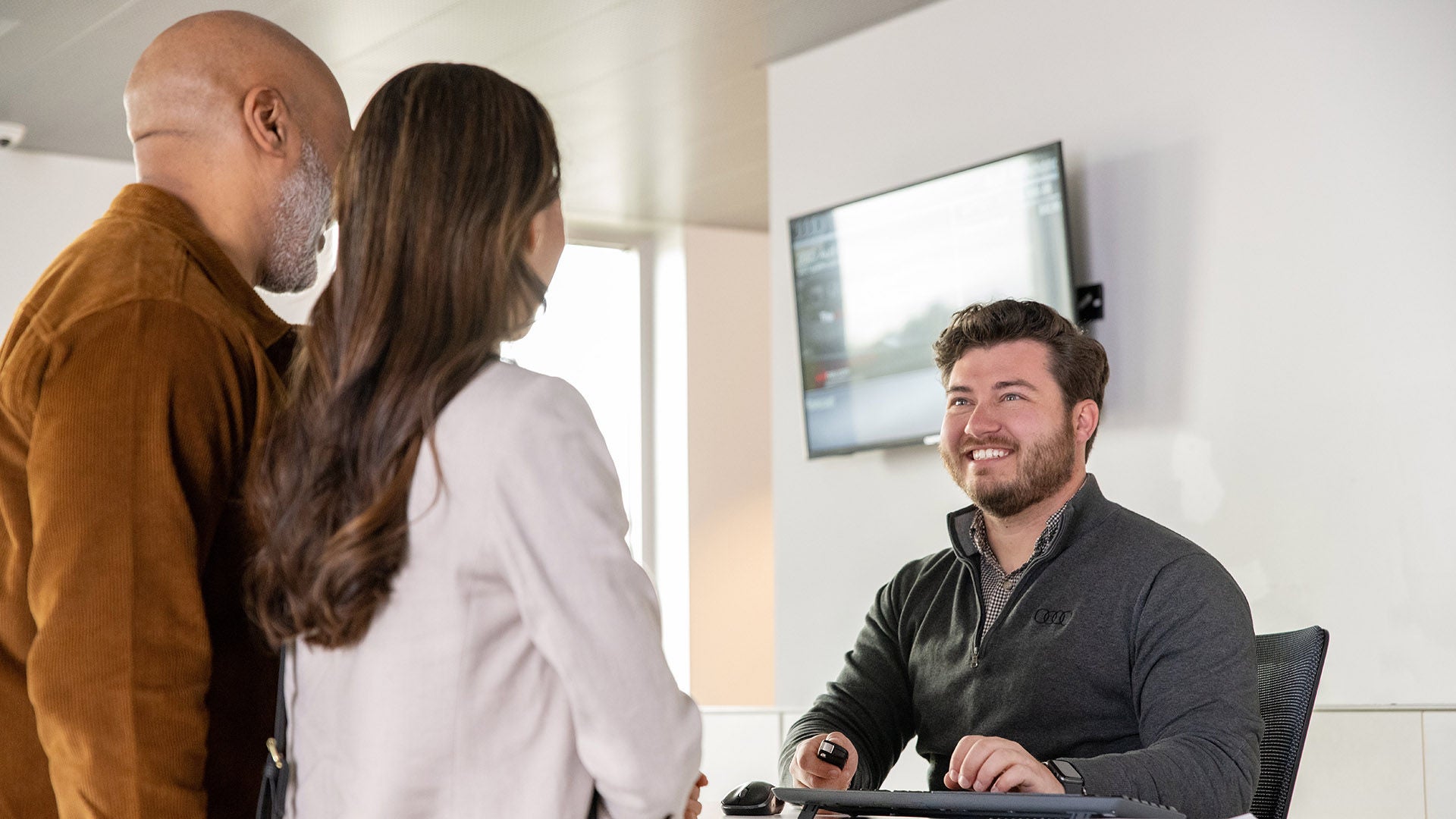 Photo of a pair of Audi customers meeting with a team member.