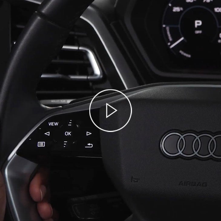  Close-up photo of the steering wheel of an Audi vehicle. 