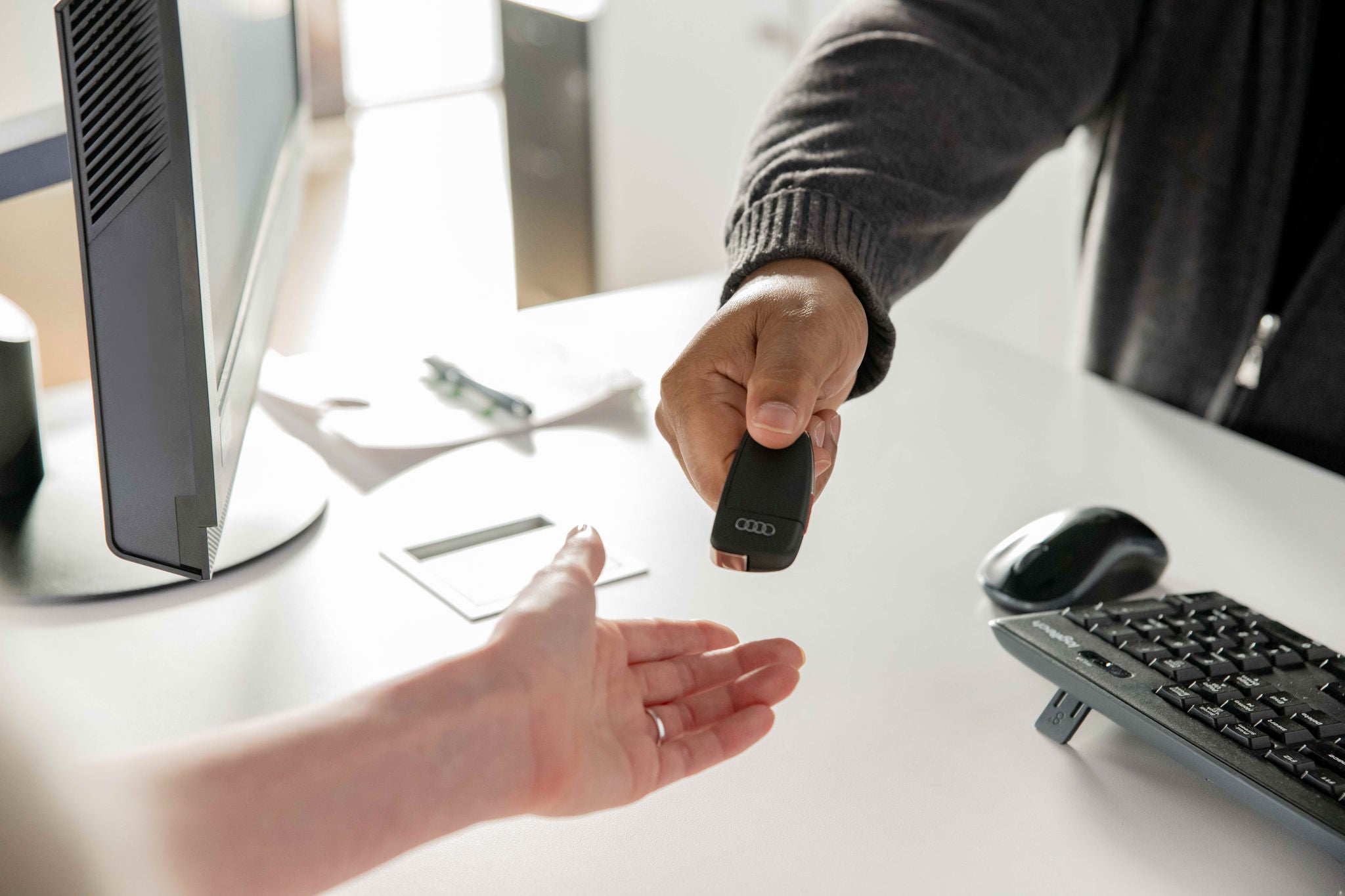 Audi Brand Ambassador handing a customer a set of keys.