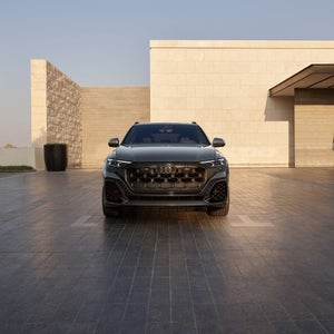 Front profile of the Audi SQ8, showing the lit up LED headlights.