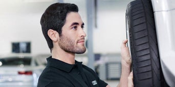 Service technician servicing tire.