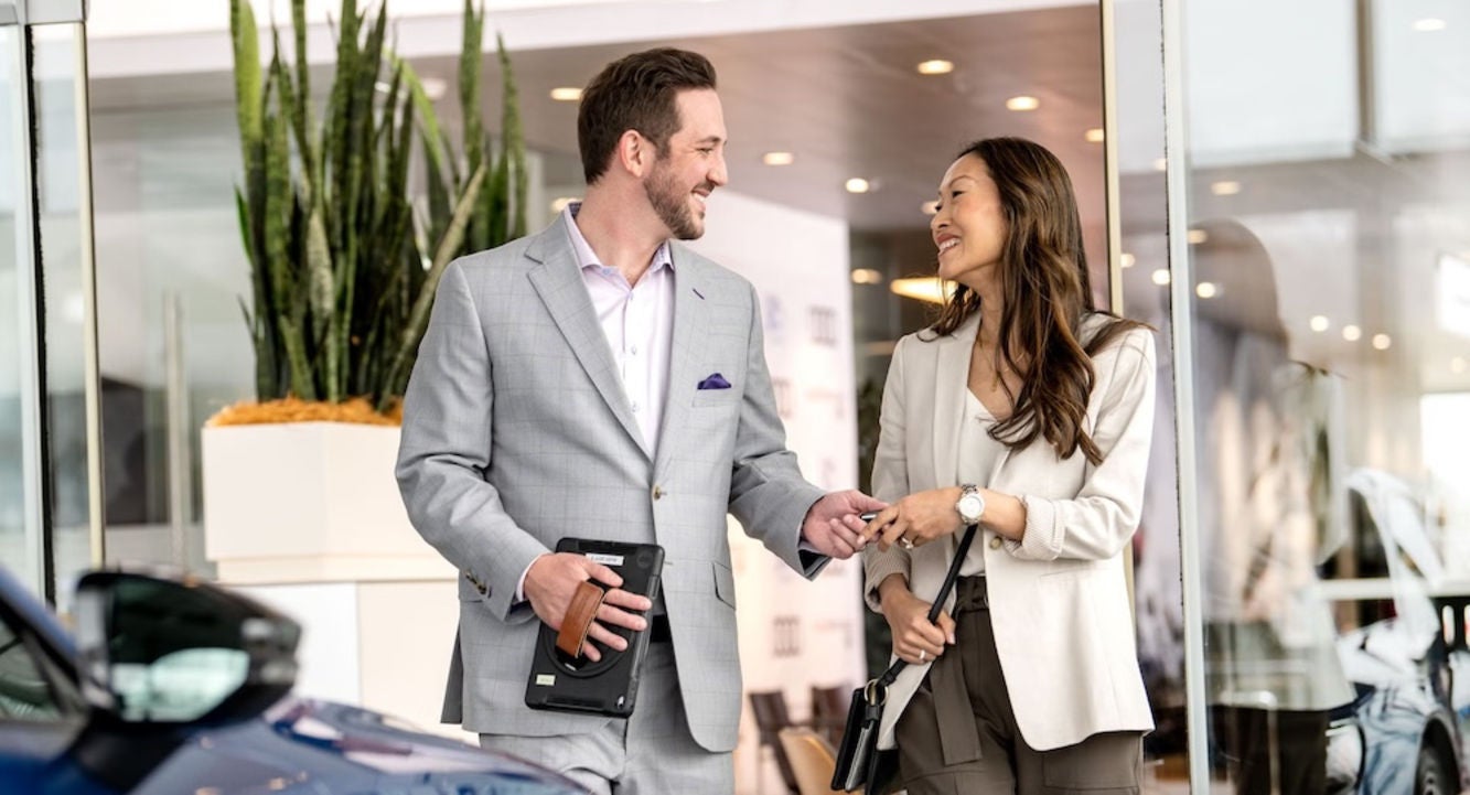 A car dealer and a customer shaking hands inside an Audi dealership