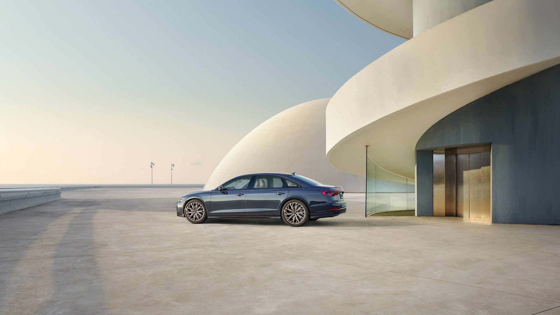 Blue Audi A8 parked in front of a modern building or residence.  