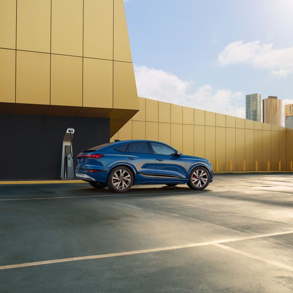 Side view of the Audi SQ6 Sportback e-tron parked and charging.