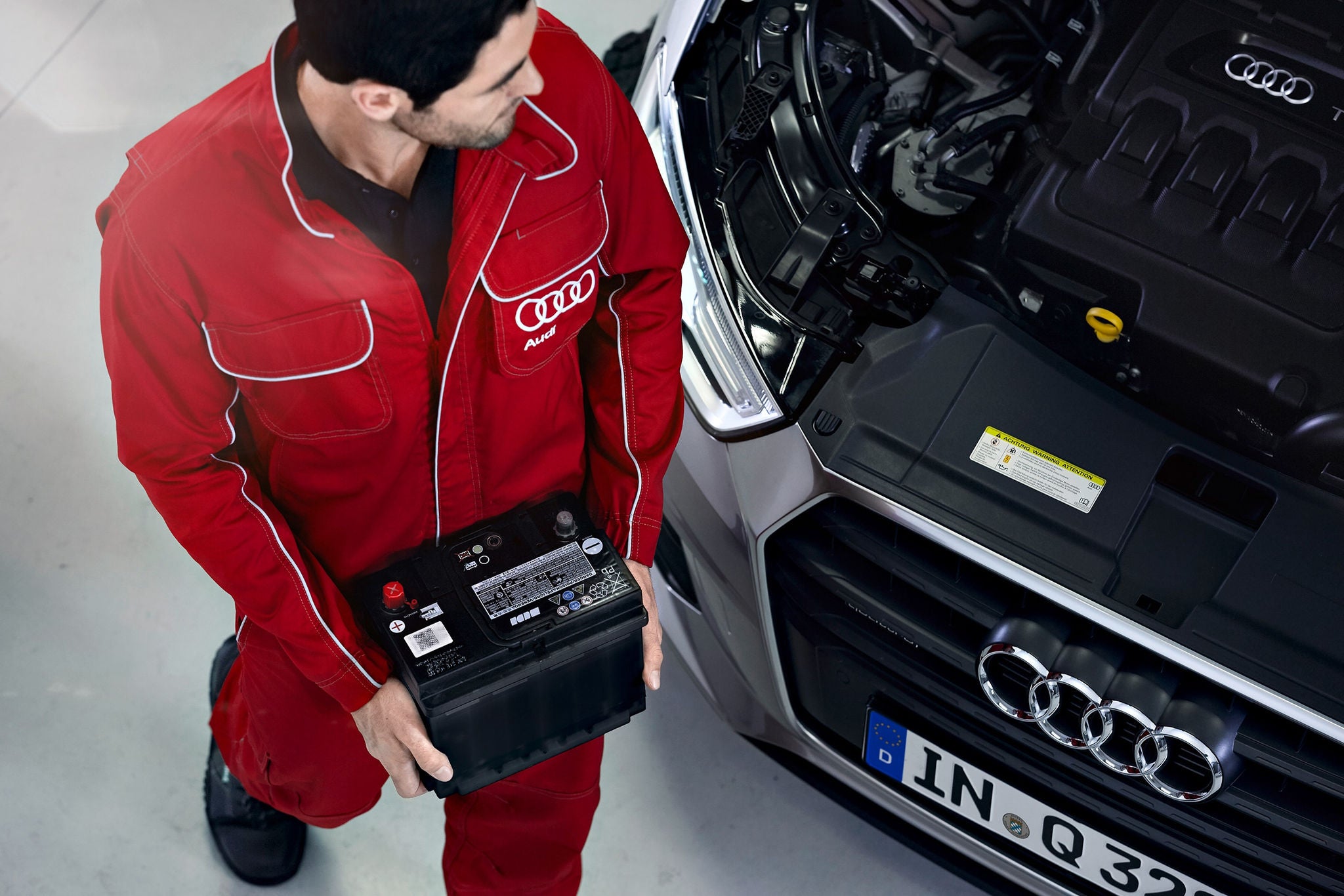 Audi technician performing battery service on a vehicle
