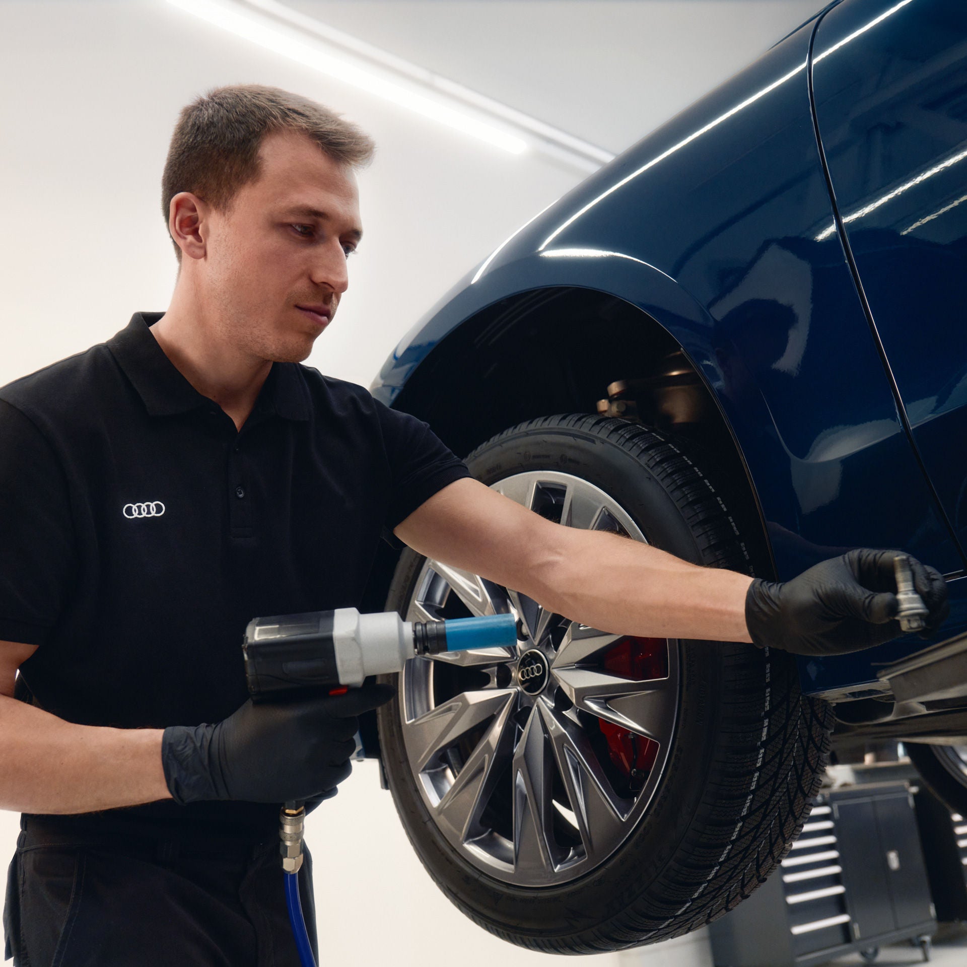 An Audi technician changing the wheels with dynamic wheelcaps on a A6 e-tron.