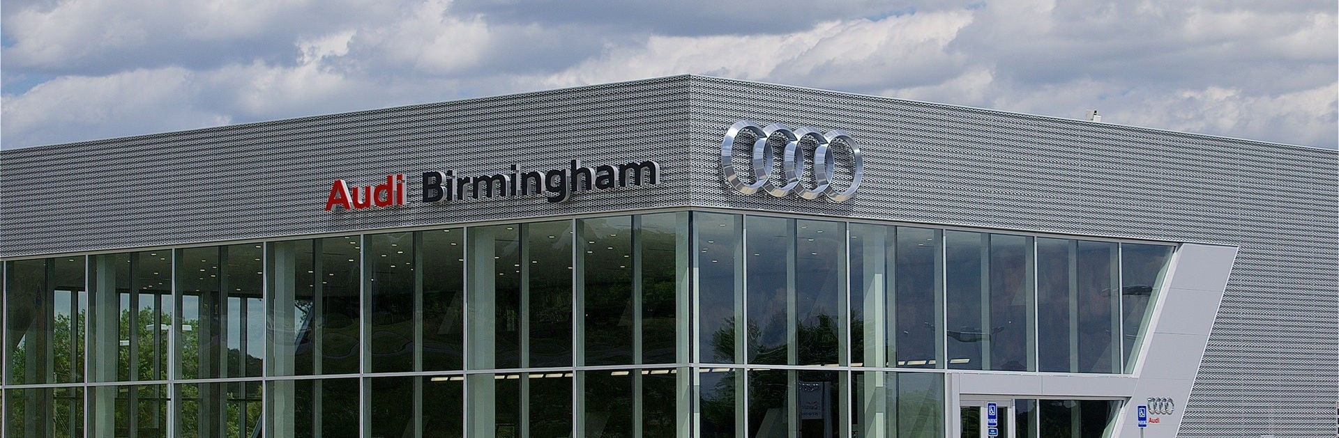 Front of the Audi Birmingham dealership with cars parked in the front.