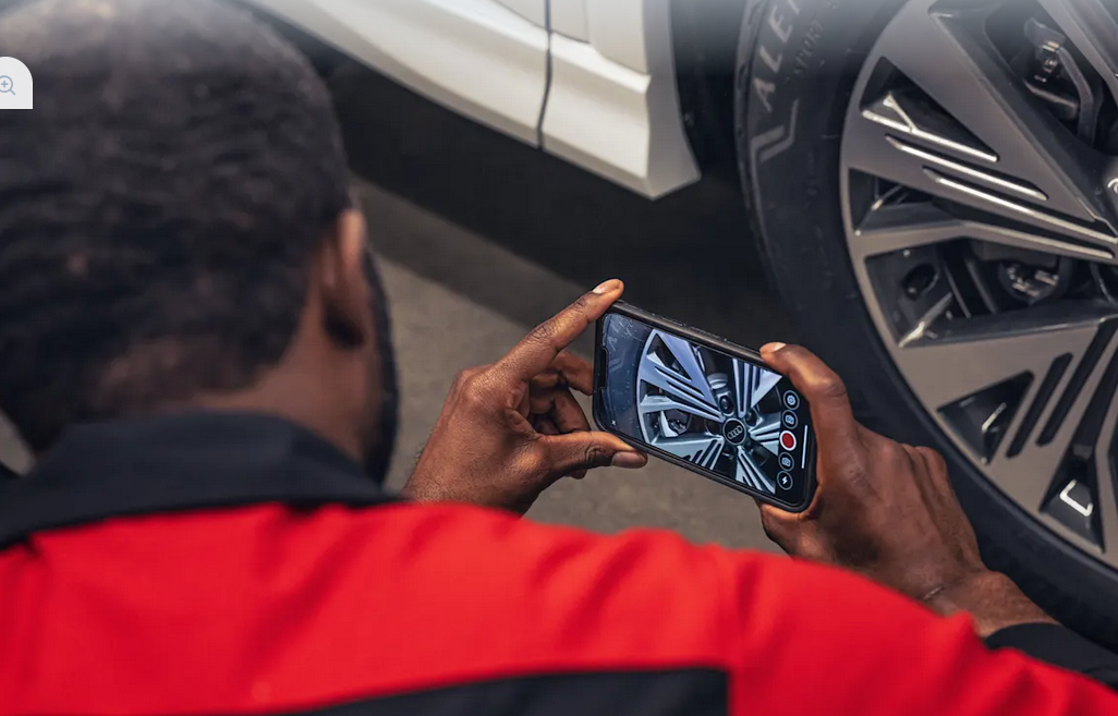 Audi service technician taking a picture of the vehicle