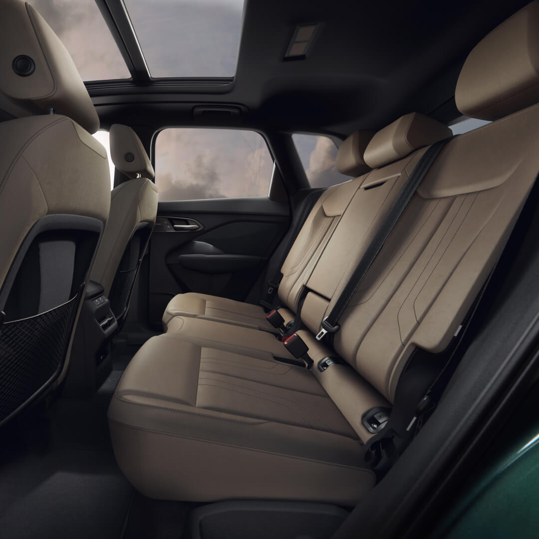 Interior view of beige leather rear seating and panoramic sunroof inside a 2026 Audi Q3.