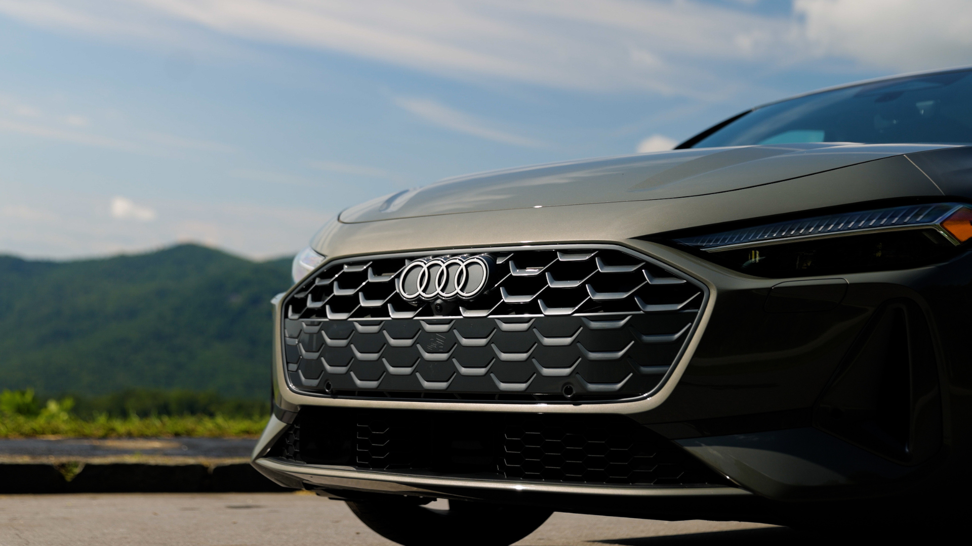 Close up of the front grille of an Audi car with mountains in the background