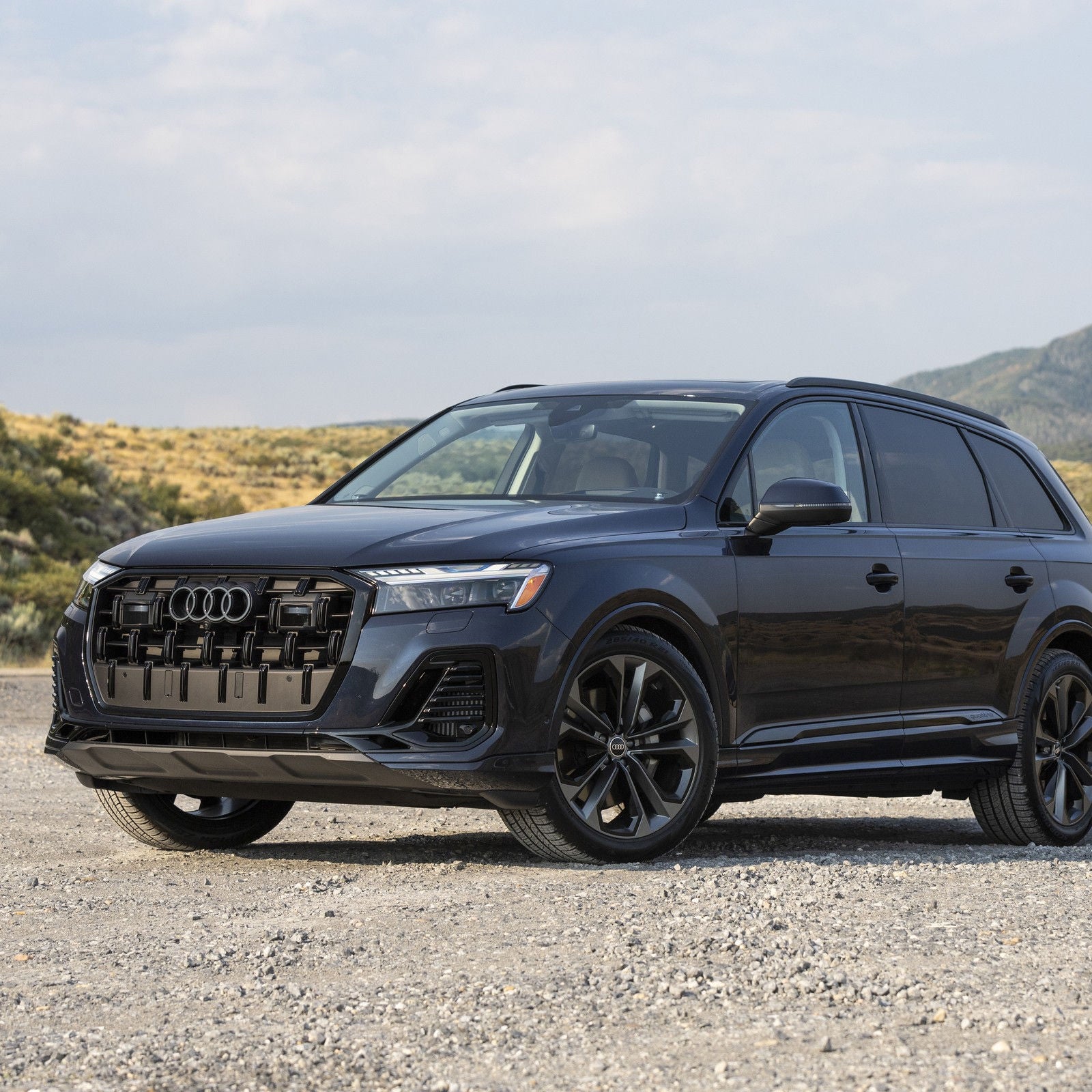 2026 Audi Q7 three-quarter front in Waitomo Blue.