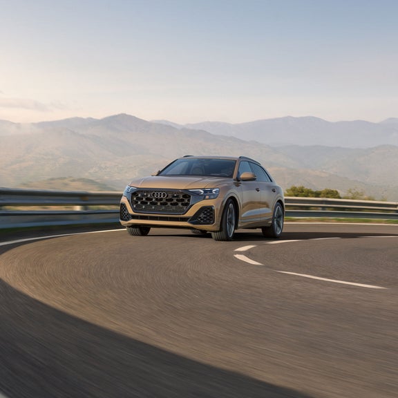 Three-quarter front view of the Audi Q8 accelerating.