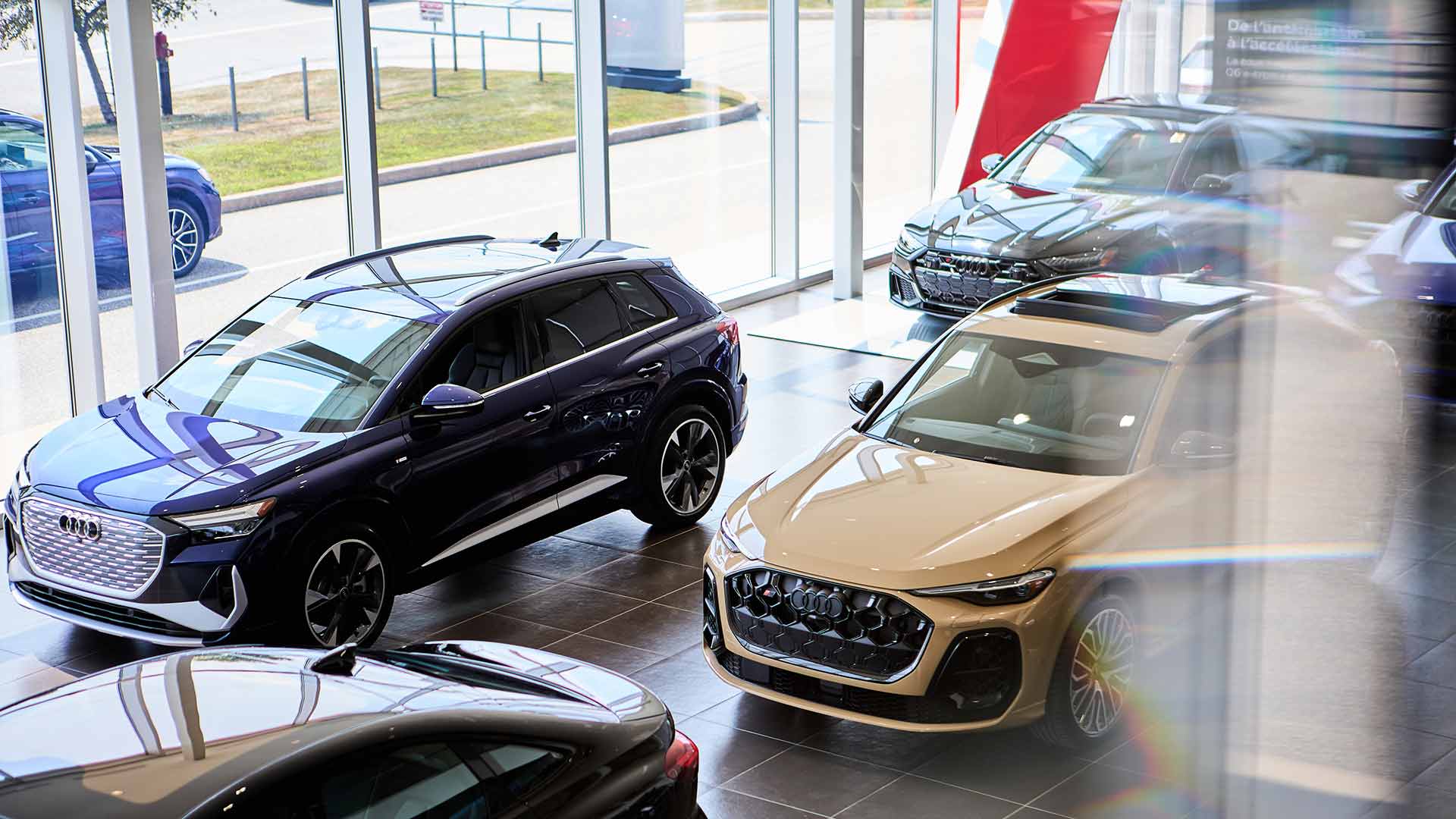 Audi vehicles displayed in the dealership's showroom.