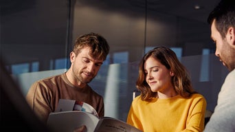 An Audi dealer speaking to two Audi customers.